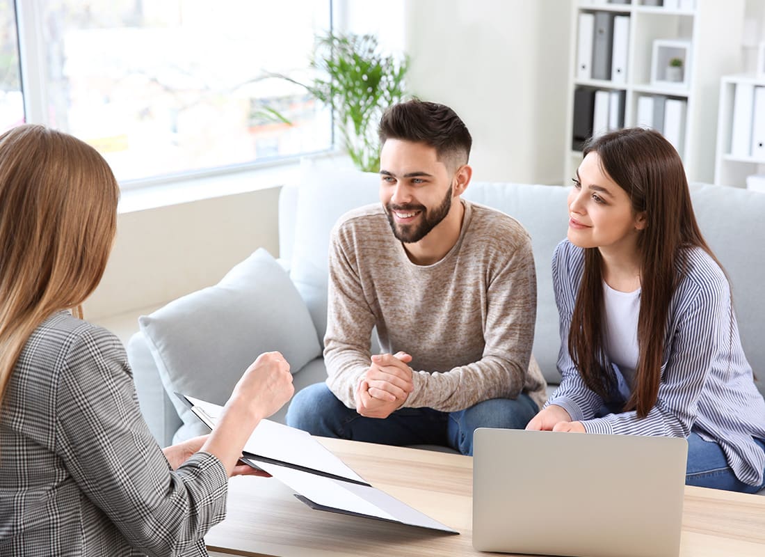Insurance Solutions - Friendly Couple and Agent Sit Down Together To Review Documents